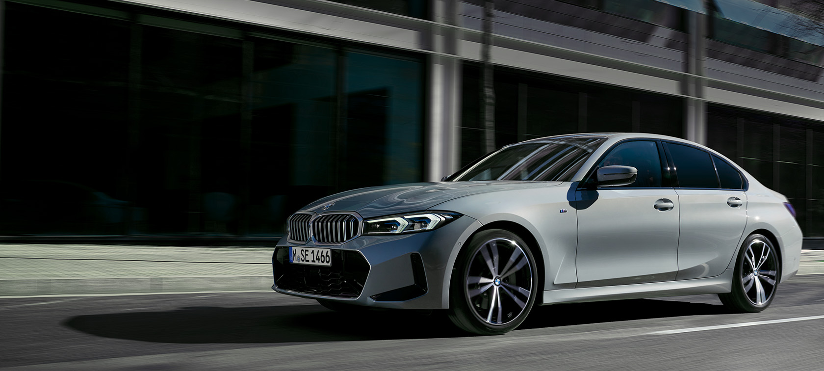 Седан BMW 3 серии LCI G20 в цвете Brooklyn Grey, вид сбоку на фоне стены